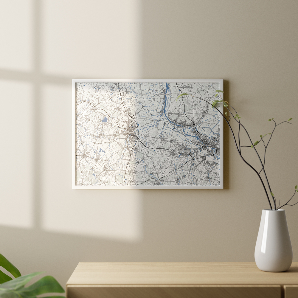 Carte géographique personnalisée dans un cadre blanc, sur un mur beige au-dessus d’un buffet en bois avec vase