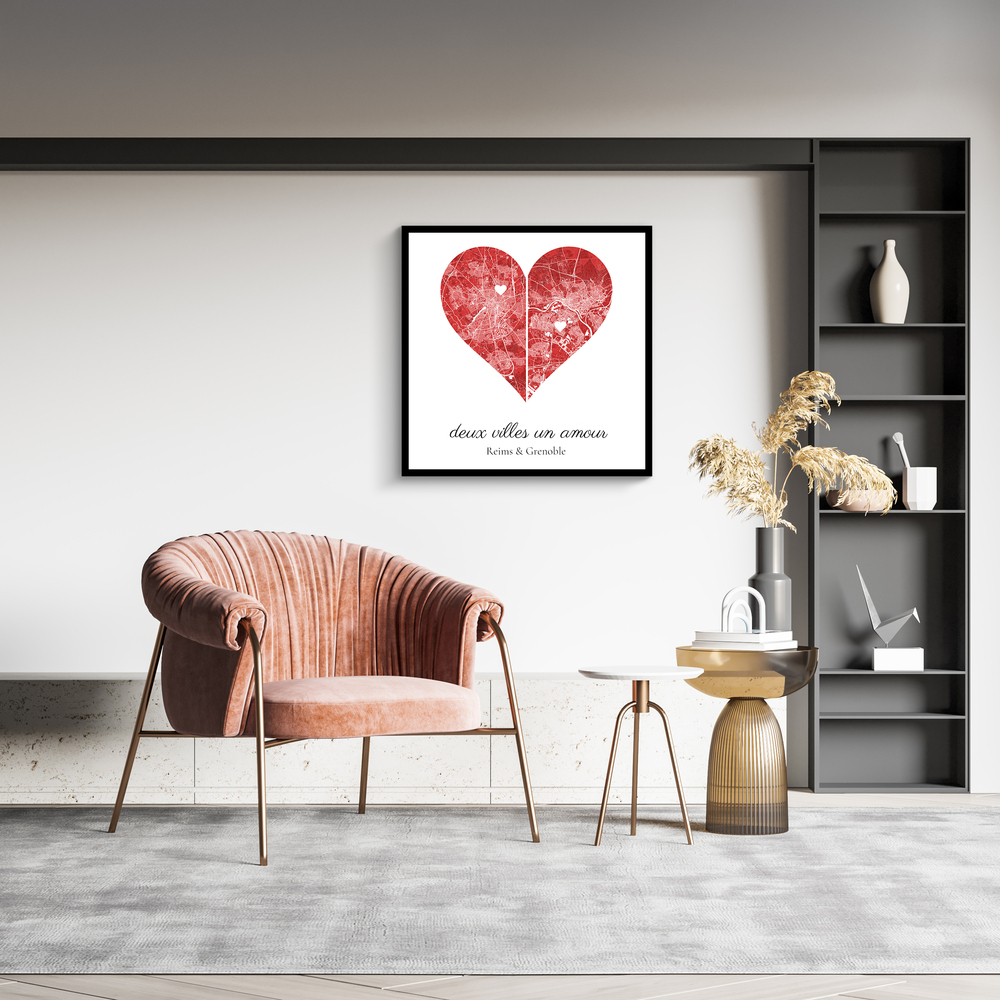 Deux plans de ville en cœur rouge dans un cadre noir au-dessus d'un fauteuil rose, un cadeau de Saint-Valentin